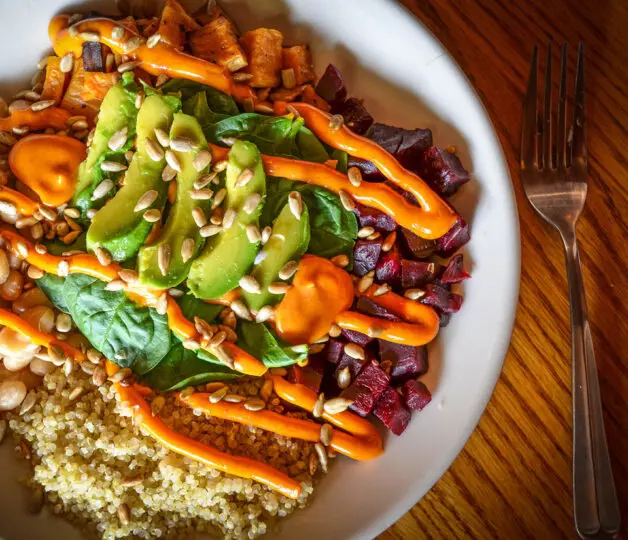 Photo of a salad with avocados, dressing, and other toppings.